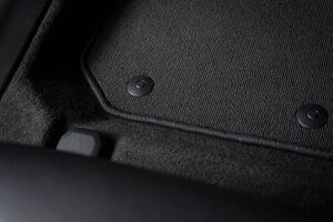 Corner of car mat with floor holder in white car interior